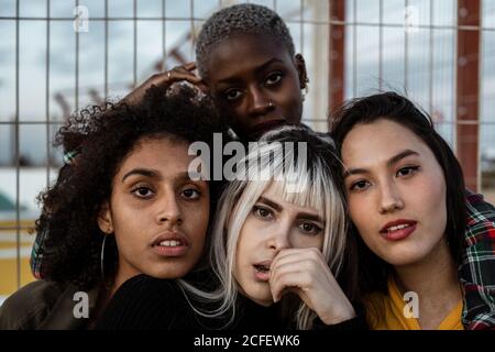 Gruppo vario di donne sorridenti che si abbracciano insieme sul prato Foto Stock