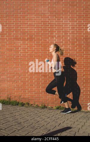 Bella giovane bionda caucasica Donna jogging all'aperto Foto Stock