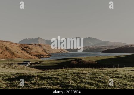 Montagna con rocce e lago contro cielo blu chiaro con raggi di sole paesaggio di natura selvaggia in autunno Foto Stock