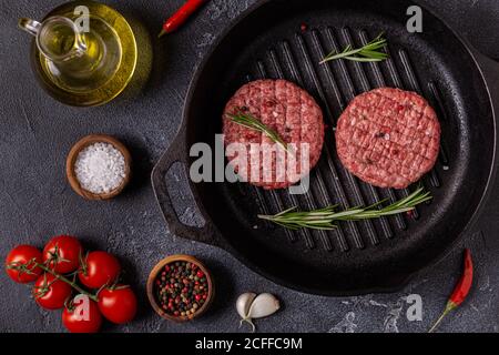 Hamburger di manzo fresco e crudi sminuzzati fatti in casa in una padella, vista dall'alto Foto Stock