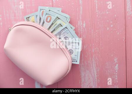 Primo piano di noi dollaro in un portafoglio su sfondo rosa. Foto Stock