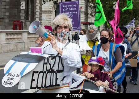 Londra, Regno Unito. 4 Settembre 2020. Gli attivisti della ribellione HS2, un gruppo di campagna a ombrello che comprende attivisti di lunga data contro il collegamento ferroviario ad alta velocità HS2 e attivisti della ribellione per l'estinzione, marciano lungo Whitehall con il manuale Boris the Bank Engine per un raduno di protesta in Parliament Square. Il rally, e un'azione di protesta successiva al Dipartimento dei Trasporti durante il quale gli attivisti si sono incollati alle porte e marciapiede all'esterno e hanno spruzzato sangue falso intorno all'ingresso, coincise con un annuncio da parte di HS2 Ltd che la costruzione del controverso £106bn ferrovia ad alta velocità Foto Stock