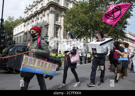 Londra, Regno Unito. 4 Settembre 2020. Gli attivisti della ribellione HS2, un gruppo di campagna a ombrello che comprende attivisti di lunga data contro il collegamento ferroviario ad alta velocità HS2 e attivisti della ribellione per l'estinzione, marciano lungo Whitehall con il manuale Boris the Bank Engine per un raduno di protesta in Parliament Square. Il rally, e un'azione di protesta successiva al Dipartimento dei Trasporti durante il quale gli attivisti si sono incollati alle porte e marciapiede all'esterno e hanno spruzzato sangue falso intorno all'ingresso, coincise con un annuncio da parte di HS2 Ltd che la costruzione del controverso £106bn ferrovia ad alta velocità Foto Stock