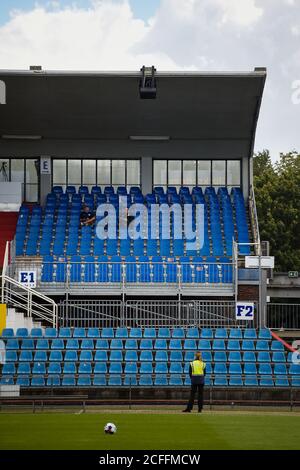 05 settembre 2020, Schleswig-Holstein, Kiel: Calcio: Test match, KSV Holstein - FC Hansa Rostock. Una stewardess è in piedi davanti allo stand quasi deserted dello spettatore. Per la prima volta 500 spettatori sono ammessi al gioco. Foto: Gregor Fischer/dpa Foto Stock