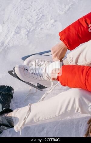 Donna seduta sulla neve e scarpe da cambio Foto Stock