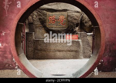 Ingresso porta luna in rosso dipinto muro di A ma tempio di Macao Foto Stock