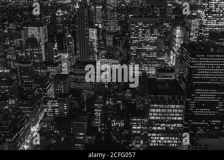 Vista aerea di megalopoli con pareti di vetro illuminate e futuristico facciate di alti grattacieli sullo sfondo in serata Foto Stock