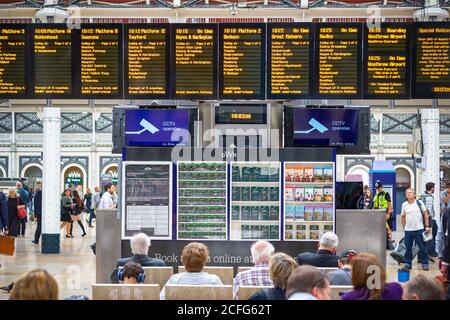 Londra, Regno Unito - 17 aprile 2019 - passeggeri che controllano gli orari e aspettano il treno alla stazione ferroviaria di Paddington Foto Stock