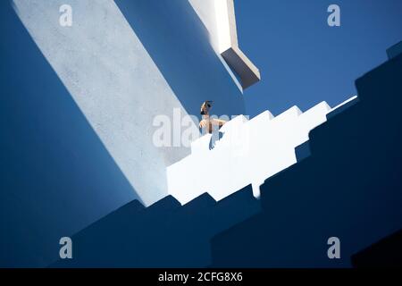 Da sotto di bracci di raccolto appesi dalla parte superiore di l'edificio che ospita un telefono cellulare Foto Stock