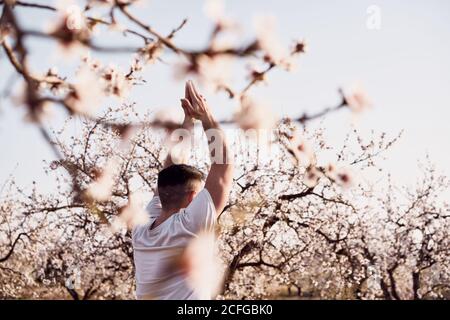 uomo che fa yoga nel giardino primaverile Foto Stock