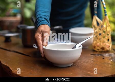 Un uomo che mette una zuppa di riso sul tavolo. Foto Stock