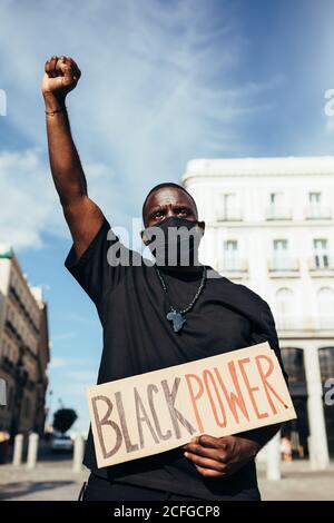 Uomo che protesta a un rally per l'uguaglianza razziale in possesso di un poster 'Black Power'. Le vite nere contano. Foto Stock
