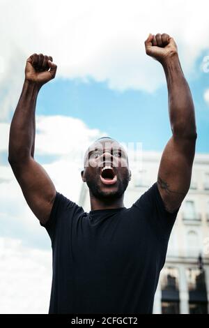 uomo che protesta a un raduno per l'uguaglianza razziale che alza le armi. Le vite nere contano. Foto Stock