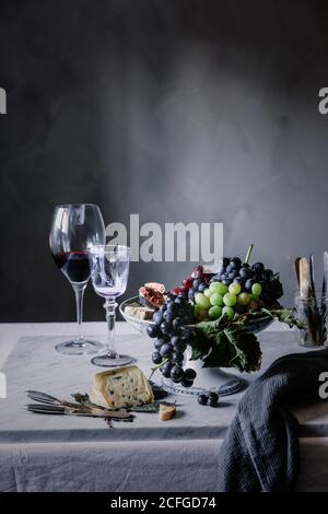 Uve con vino e formaggio blu servite a tavola per cena Foto Stock