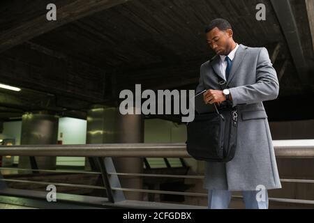Bell'uomo afroamericano in borsa per il controllo della tuta Foto Stock