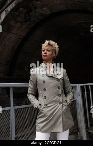 Ritratto di una donna allegra afro-americana elegante in cappotto Foto Stock