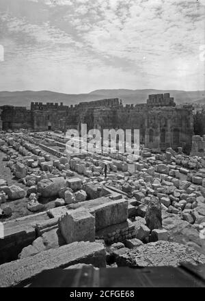 Didascalia originale: Baalbek. Grande corte che mostra i templi di Giove & Bacco guardando S.E. - Ubicazione: Libano--BaÊ»labakk ca. 1936 Foto Stock