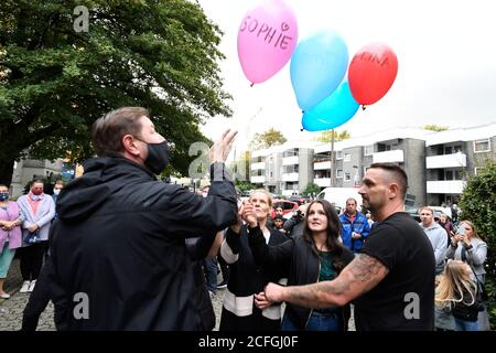 Solingen, Germania. 05 settembre 2020. Insieme al sindaco Tim Kurzbach (l), i vicini hanno lasciato cinque palloncini con i nomi dei cinque bambini uccisi risorgere di fronte alla casa della famiglia come espressione del loro dolore. Solingen è in lutto per cinque bambini che sono morti violentemente. Si dice che la madre di 27 anni della famiglia Solingen abbia prima anestetizzato e poi soffocato i suoi figli di uno-otto anni. È stato emesso un mandato di arresto per la donna. Credit: Roberto Pfeil/dpa/Alamy Live News Foto Stock