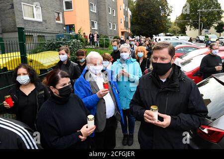 Solingen, Germania. 05 settembre 2020. Il sindaco Tim Kurzbach (r) tiene una candela nelle sue mani mentre lui e molte altre persone si trovano di fronte alla casa dove cinque bambini sono stati trovati morti come espressione di dolore. Solingen è in lutto per cinque bambini che sono morti violentemente. Si dice che la madre di 27 anni della famiglia Solingen abbia prima anestetizzato e poi soffocato i suoi figli di uno-otto anni. È stato emesso un mandato di arresto per la donna. Credit: Roberto Pfeil/dpa/Alamy Live News Foto Stock