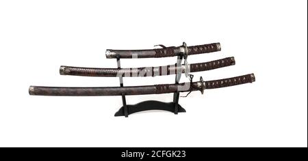 Tre spade samurai su un supporto su sfondo bianco Foto Stock
