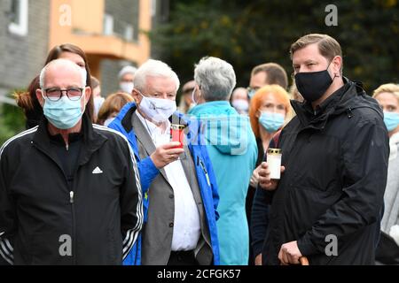 Solingen, Germania. 05 settembre 2020. Il sindaco Tim Kurzbach (r) tiene una candela nelle sue mani mentre lui e gli altri si trovano di fronte alla casa dove cinque bambini sono stati trovati morti come espressione di dolore. Solingen è in lutto per cinque bambini che sono morti violentemente. Si dice che la madre di 27 anni della famiglia Solingen abbia prima anestetizzato e poi soffocato i suoi figli di uno-otto anni. È stato emesso un mandato di arresto per la donna. Credit: Roberto Pfeil/dpa/Alamy Live News Foto Stock