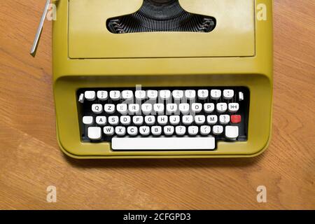 Vista dall'alto verso il basso sulla tastiera alfanumerica di un vecchio macchina da scrivere retro su una scrivania in legno in una comunicazione o. concetto aziendale Foto Stock