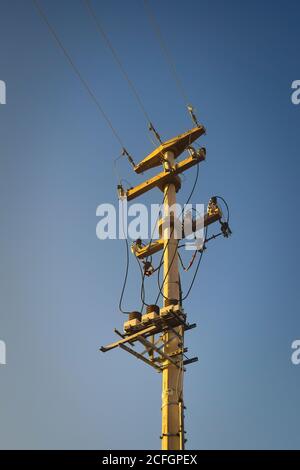 Pilone elettrico e linee elettriche contro il cielo blu. Infrastruttura, concetto di alimentazione. Foto Stock