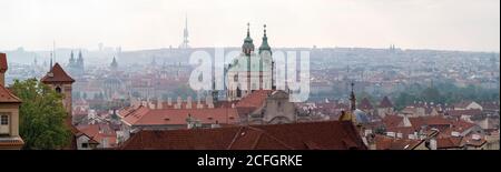 Praga dal Castello: Un mistico panorama della città e delle sue guglie di prima mattina dai terreni del castello. La cupola di San Nicola domina il primo piano con il Ponte Carlo al centro e la chiesa di Pietro e Paolo e l'imponente torre della televisione di Žižkov all'orizzonte. Foto Stock