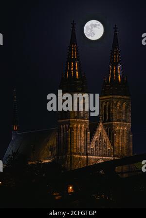 Cattura della luna piena centrata tra le guglie di Chiesa di Vyserad a Praga Foto Stock