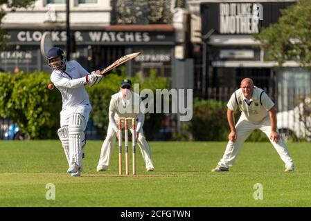 Cricket in esecuzione a Chalkwell Park, Westcliff on Sea, Southend, Essex, Regno Unito. Belhus Cricket Club battsman batting, con scivoli fielding Foto Stock