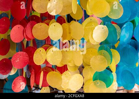 uno sfondo di paillettes e dischi dai colori vivaci appesi in corde che formano mobili e decorazioni. Foto Stock