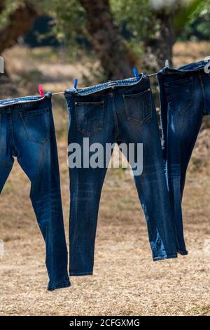 paia di jeans che asciugano su una linea di lavaggio. Foto Stock