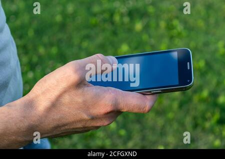 uomo mano che tiene il telefono cellulare Foto Stock