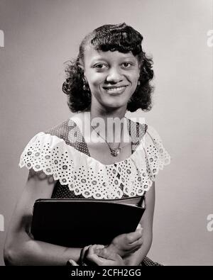 1950 AFRICAN AMERICAN DONNA STUDENTE UNIVERSITARIO TENENDO BINDER