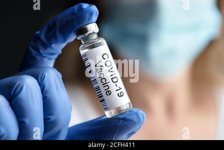 Il medico tiene in laboratorio il flacone con il vaccino COVID-19. Ricercatore femminile e virus corona vaccino per la cura COVID. Concetto di medicina, tria clinica Foto Stock