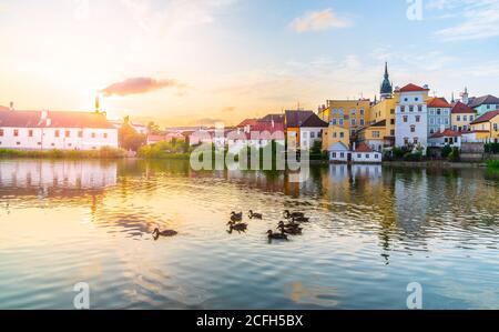 Jindrichuv Hradec paesaggio urbano al tramonto riflesso nel piccolo stagno di Vajgar con gregge di anatre, Repubblica Ceca. Foto Stock