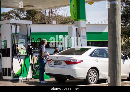 L'uomo australiano in una stazione di servizio BP riempie il suo Auto con benzina, Sydney, Australia Foto Stock
