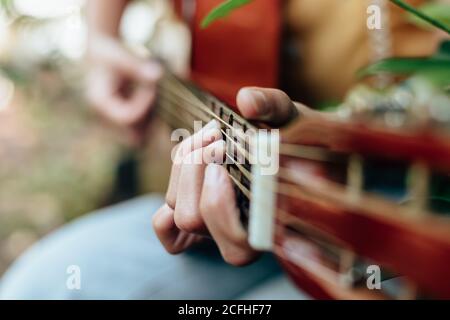 le mani della donna che suonano la chitarra acustica si divertono all'aperto, primo piano. Foto Stock