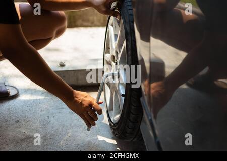 Uomo cambio pneumatico con chiave per ruota Foto Stock