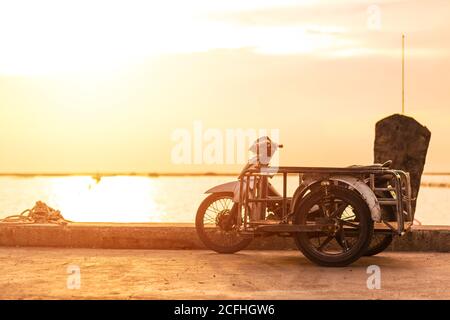 motocicletta sidecar vicino al mare con tramonto. Foto Stock