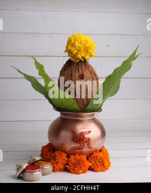 kalash di rame con noce di cocco e foglie di mango con haldi kumkum e decorazione floreale. essenziale in puja indù. Foto Stock