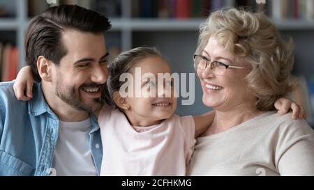 Primo piano su bambina bella abbracciando padre e nonna Foto Stock