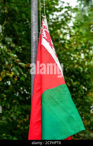 Bandiera bielorussa sgualcita su un vecchio flagpole per strada. Foto Stock