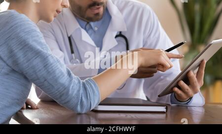 Primo piano medico terapeuta che consulta la paziente femminile, utilizzando la compressa Foto Stock