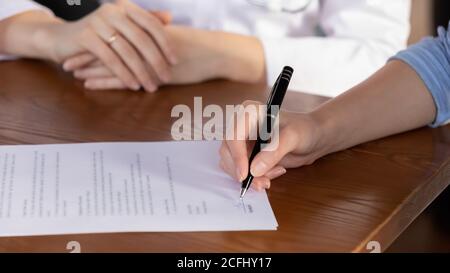 Primo piano donna che firma l'accordo di assicurazione medica alla riunione Foto Stock