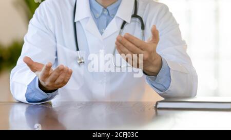 Primo piano medico terapista che consulta il paziente, seduto al tavolo Foto Stock