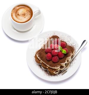 Porzione di tipico dessert tiramisù con lamponi e una tazza di espresso caldo fresco isolato su sfondo bianco - percorso di ritaglio Foto Stock