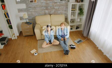 Fidanzato e fidanzato che gioca a videogiochi con controller wireless. Foto Stock