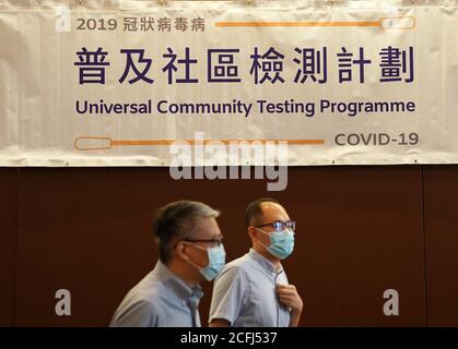 Hong Kong, Cina. 1 settembre 2020. La gente passa accanto a un poster del programma di test della comunità universale a Hong Kong, Cina meridionale, 1 settembre 2020. PER ANDARE CON 'Feature: Esperti medici continentali che combattono COVID-19 a Hong Kong' Credit: Li Gang/Xinhua/Alamy Live News Foto Stock