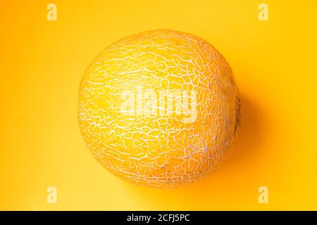 Melone maturo su sfondo giallo. Vista dall'alto, disposizione piatta Foto Stock